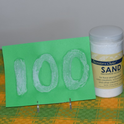 Make this sensory 100 day sign with sand.