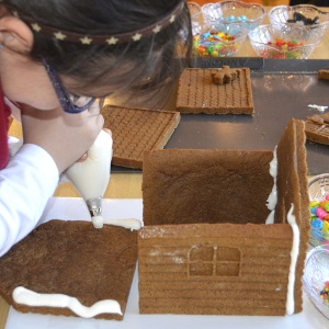 Gluing the sides of a gingerbread house with icing.