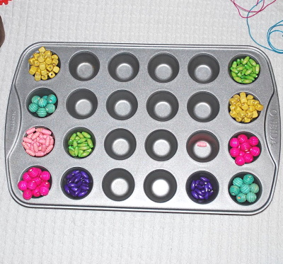 Sorting beads in muffin tins.