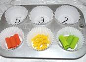 counting colored pasta in muffin tins