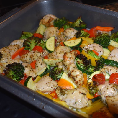 Roasted veggies and chicken cooked in pan.