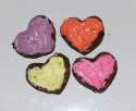 Small heart brownies with colored frosting.